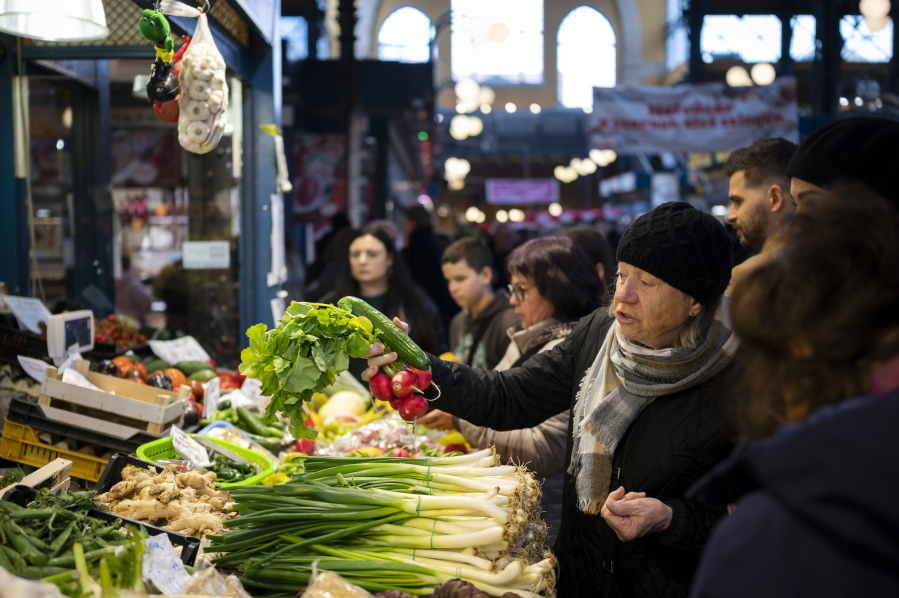 Pakistani shoppers purchase vegetables from a stall inside a