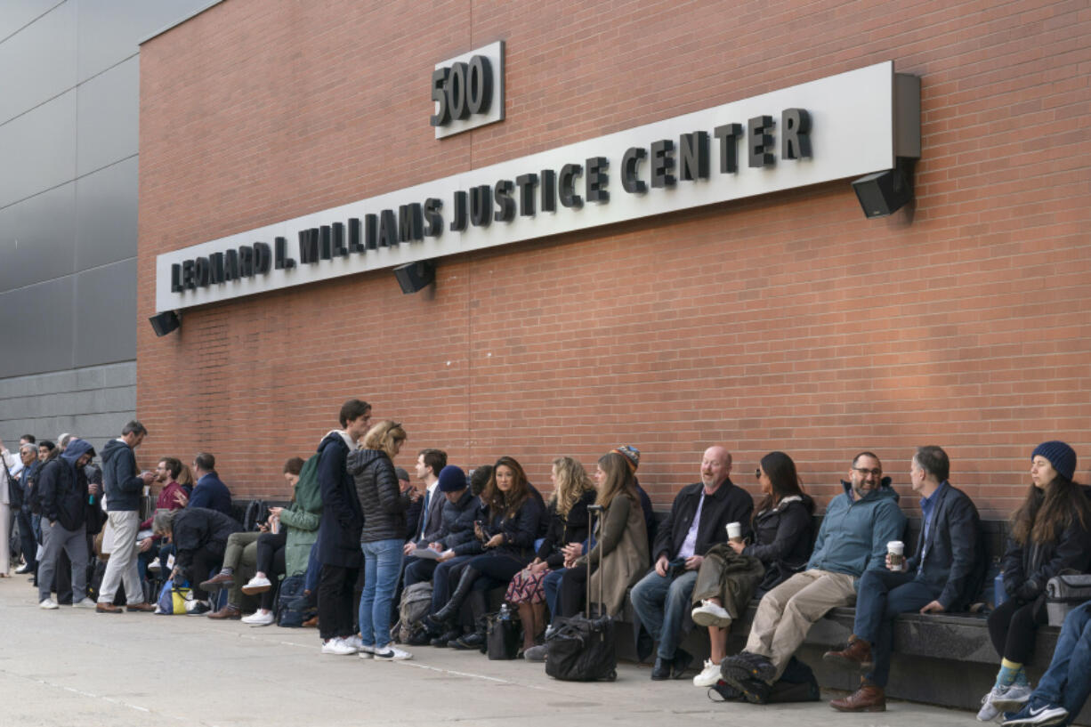 People including those planing to attend the Dominion Voting Systems' defamation lawsuit against Fox News wait to enter the justice center in Wilmington, Del., Tuesday, April 18, 2023.