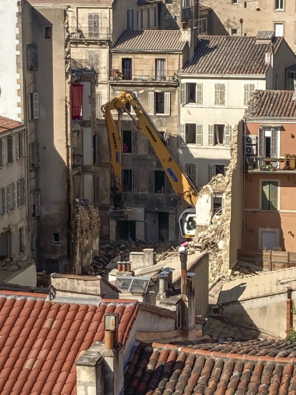 An excavator clears debris on the scene where a building collapsed, in Marseille, southern France, April 10, 2023.Two bodies were found overnight in the rubble following an explosion that collapsed a building in the southern French city of Marseille, as rescuers continued searching for at least six people who are unaccounted-for, authorities said Monday..