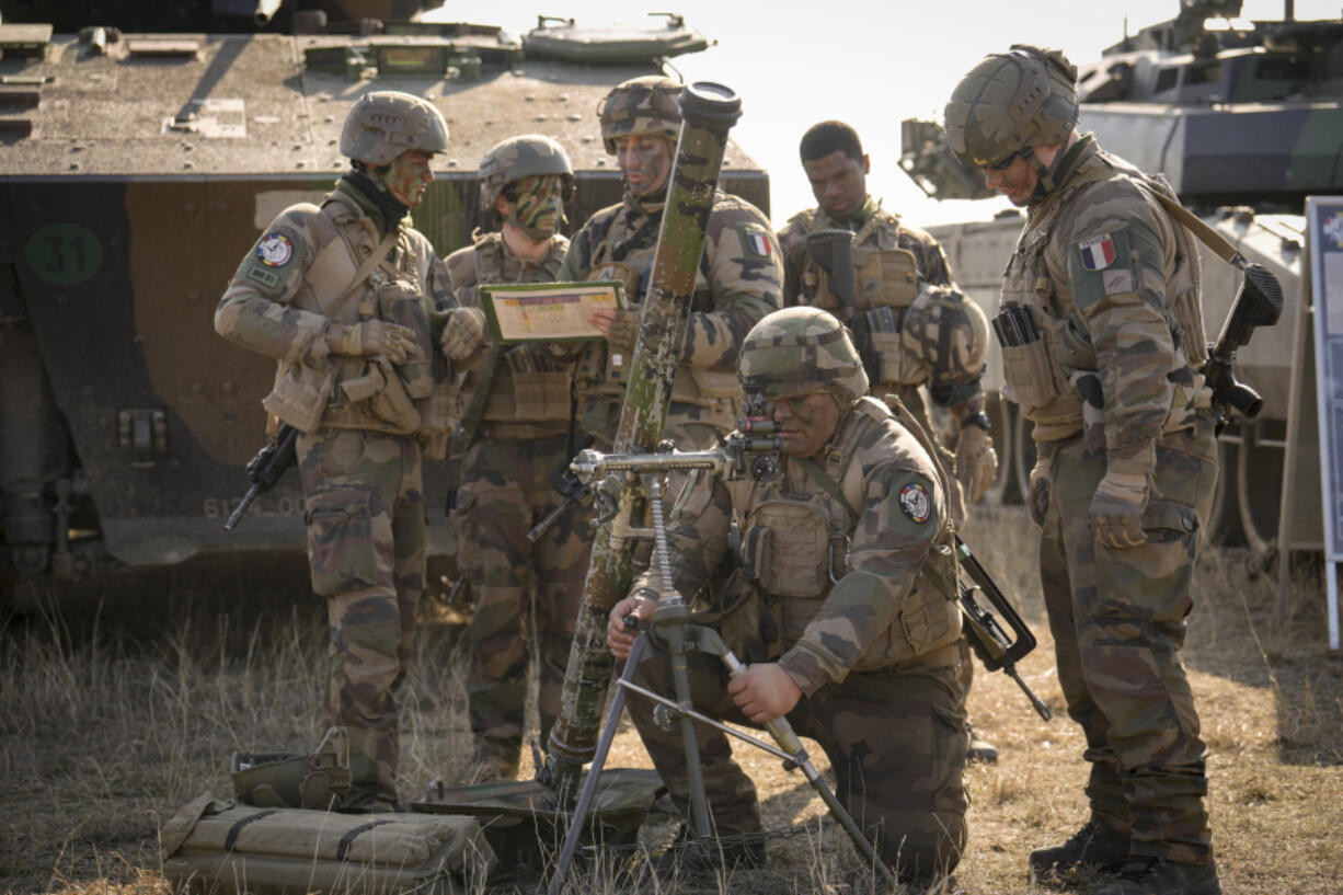 FILE - French serviceman operate a mortar during a joint French US exercise involving HIMARS and MLRP rocket launchers at a firing range in Capu Midia, on the Black Sea shore, Romania, Thursday, Feb. 9, 2023 as U.S. and French troops are part of a NATO battlegroup in Romania holding a military exercise. The French government approved on Tuesday April 4, 2023 in Cabinet meeting a key budget bill presented as the biggest military spending effort for France since the 1960s and meant to take into account the impact of Russia's war in Ukraine.