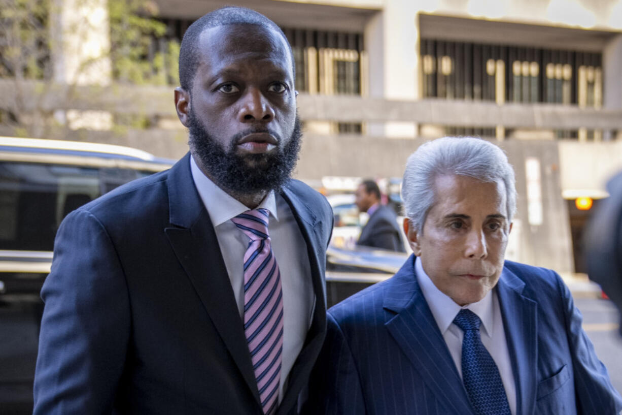 FILE - Prakazrel "Pras" Michel, left, a member of the 1990s hip-hop group the Fugees, accompanied by defense lawyer David Kenner, right, arrives at federal court for his trial in an alleged campaign finance conspiracy, Thursday, March 30, 2023, in Washington. Michel, who was accused in multimillion-dollar political conspiracies spanning two presidencies, was convicted Wednesday, April 26, after a trial that included testimony ranging from actor Leonardo DiCaprio to former U.S. Attorney General Jeff Sessions.