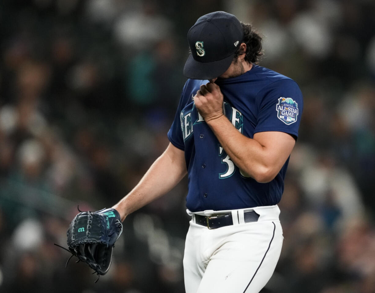 Seattle Mariners starting pitcher Robbie Ray wipes his face as he walks off of the field after being removed during the fourth inning of the team's baseball game against the Cleveland Guardians on Friday, March 31, 2023, in Seattle.