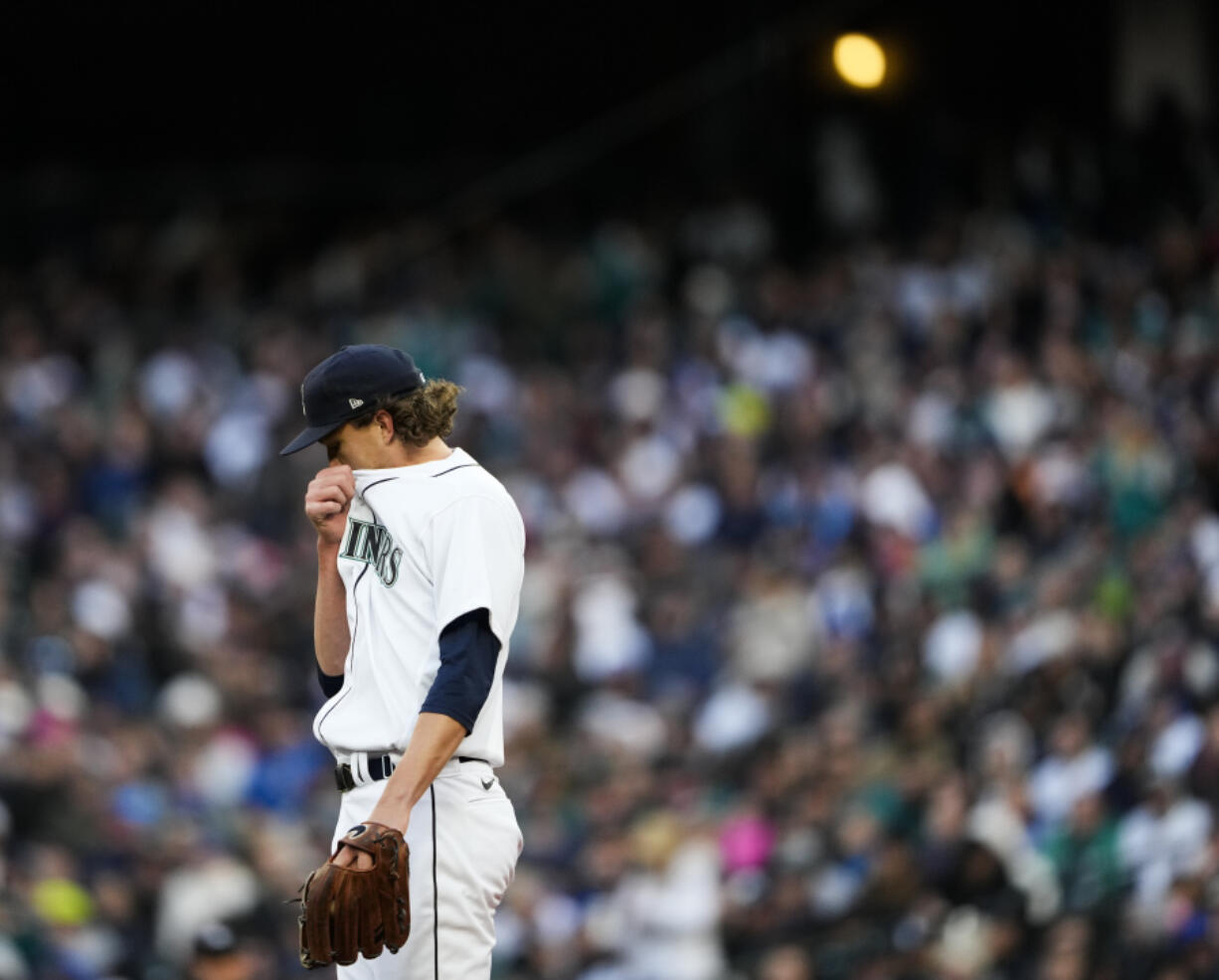 Seattle Mariners starting pitcher Logan Gilbert wipes his face after walking Cleveland Guardians designated hitter Josh Bell in the first inning during a baseball game Saturday, April 1, 2023, in Seattle.