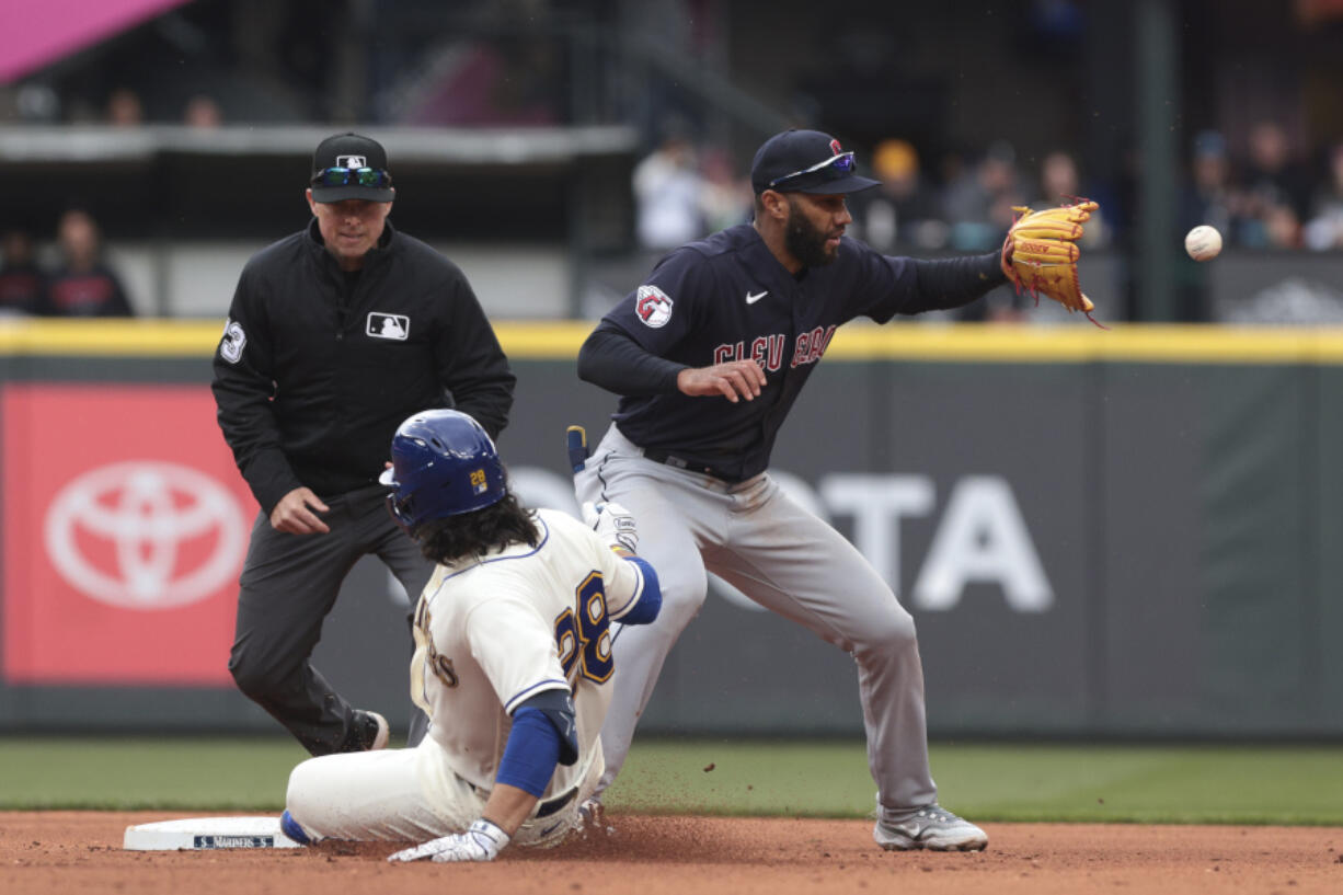 Seattle Mariners' Eugenio Suarez, front left, is safe at second base as Cleveland Guardians shortstop Amed Rosario, right, receives the throw during the fifth inning of a baseball game, Sunday, April 2, 2023, in Seattle.