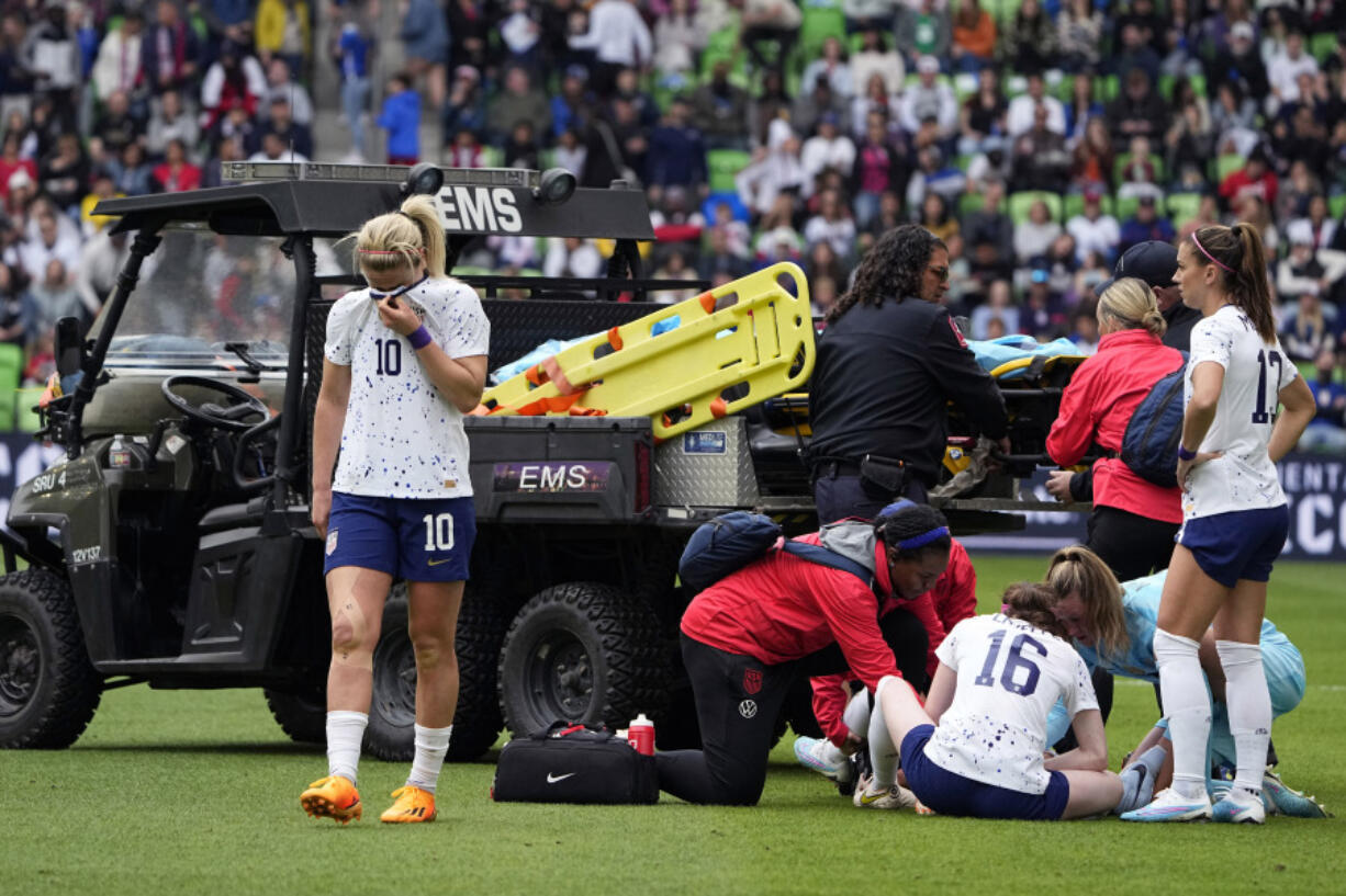 United States midfielder Lindsey Horan (10) and other players stands by as teammate Mallory Swanson receives medical attention after an injury in the first half of an international friendly soccer match against Ireland in Austin, Texas, Saturday, April 8, 2023.