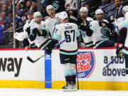 Seattle Kraken center Morgan Geekie (67) is congratulated for his goal against the Colorado Avalanche during the third period of Game 1 of a first-round NHL hockey playoff series Tuesday, April 18, 2023, in Denver.