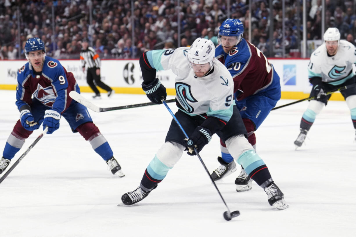 Seattle Kraken center Ryan Donato (9) is defended by Colorado Avalanche center Lars Eller (20) during the second period of Game 2 of a first-round NHL hockey playoff series Thursday, April 20, 2023, in Denver.