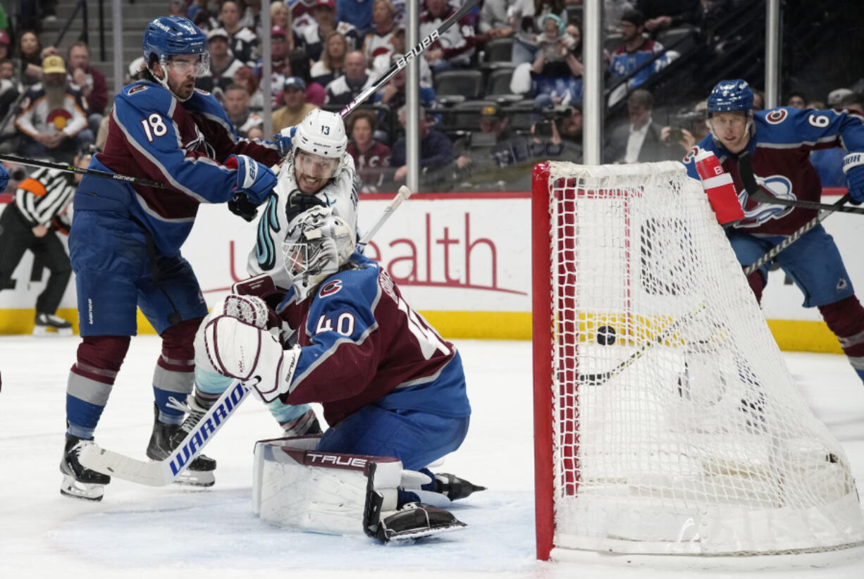 Seattle Kraken left wing Brandon Tanev, right, watches as his shot goes in for a goal past Colorado Avalanche goaltender Alexandar Georgiev (40) as Avalanche center Alex Newhook (18) looks on in the second period of Game 7 of an NHL first-round playoff series Sunday, April 30, 2023, in Denver.