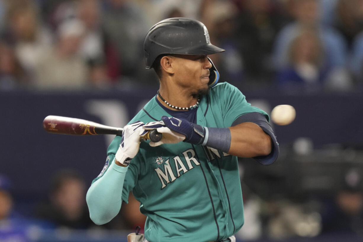 Seattle Mariners' Julio Rodriguez tries to dodge a pitch from Toronto Blue Jays' Alek Manoah during the second inning of a baseball game Friday, April 28, 2023, in Toronto.