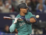 Seattle Mariners' Julio Rodriguez tries to dodge a pitch from Toronto Blue Jays' Alek Manoah during the second inning of a baseball game Friday, April 28, 2023, in Toronto.