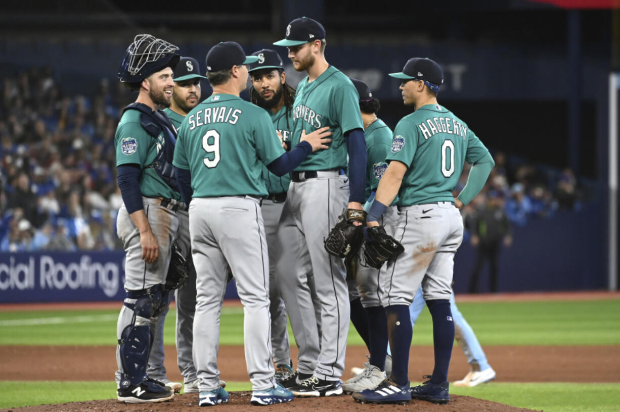 Seattle Mariners starting pitcher Easton McGee, center, is taken out of the game by manager Scott Servais (9) during the seventh inning of a baseball game against the Toronto Blue Jays in Toronto, Saturday, April 29, 2023.