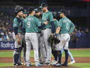 Seattle Mariners starting pitcher Easton McGee, center, is taken out of the game by manager Scott Servais (9) during the seventh inning of a baseball game against the Toronto Blue Jays in Toronto, Saturday, April 29, 2023.