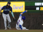 Chicago Cubs' Ian Happ, right, steals second base as Seattle Mariners shortstop J.P. Crawford, left, misses a catch during the fourth inning of a baseball game in Chicago, Monday, April 10, 2023. (AP Photo/Nam Y.