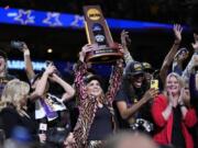 LSU head coach Kim Mulkey holds the winning trophy after the NCAA Women's Final Four championship basketball game against Iowa Sunday, April 2, 2023, in Dallas. LSU won 102-85 to win the championship.