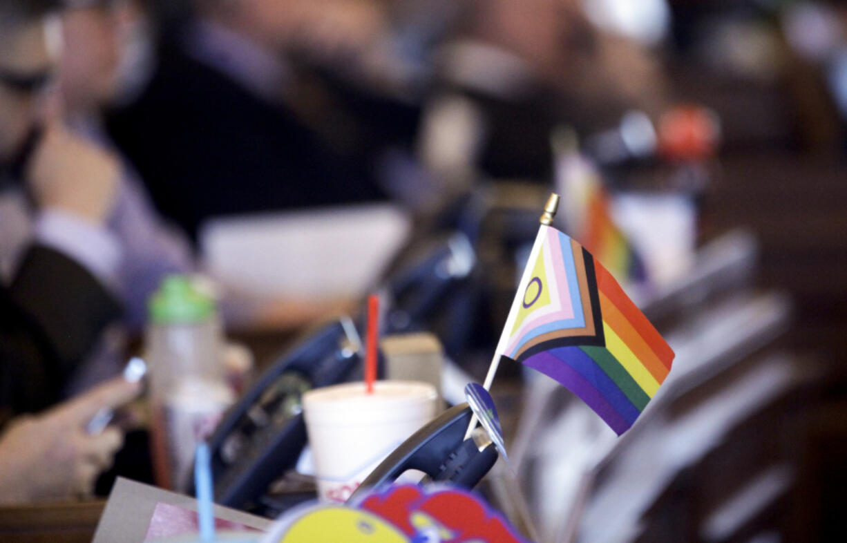 FILE - A flag supporting LGBTQ+ rights decorates a desk on the Democratic side of the Kansas House of Representatives during a debate, March 28, 2023, at the Statehouse in Topeka, Kan.  On Friday, April 28,  The Associated Press reported on stories circulating online incorrectly claiming a new law in Kansas, which bans transgender athletes from girls' and women's sports, authorizes genital inspections of children.