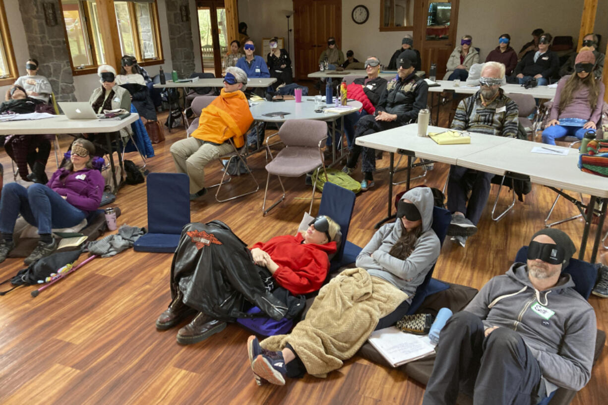 FILE - Psilocybin facilitator students sit with eye masks on while listening to music during an experiential activity at a training session run by InnerTrek near Damascus, Ore., on Dec. 2, 2022. Oregon's pioneering experiment with legalized magic mushrooms took a step closer to reality as the first "facilitators" who will accompany clients as they experience the drug received their state licenses, authorities said Tuesday, April 18, 2023.
