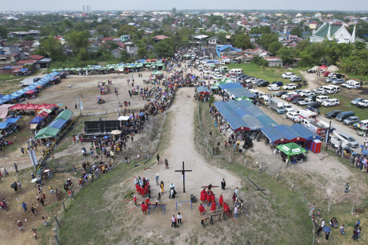 A woman penitent who is nailed to a wooden cross participates during a reenactment of Jesus Christ's sufferings as part of Good Friday rituals April 7, 2023 in the village of San Pedro, Cutud, Pampanga province, northern Philippines.