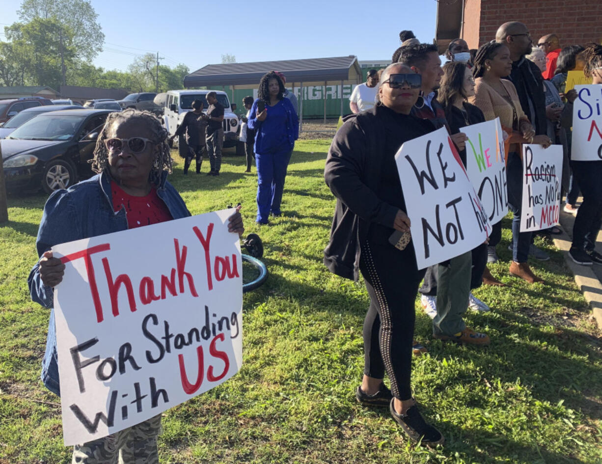 Glenda Austin of Idabel, Okla., holds a sign with other protesters, Monday, April 17, 2023, outside the McCurtain County Commissioners meeting room in Idabel, Okla. A number of McCurtain County residents were outraged by comments made by local officials on a recording and are asking for the resignation of the sheriff, two county commissioners and others.