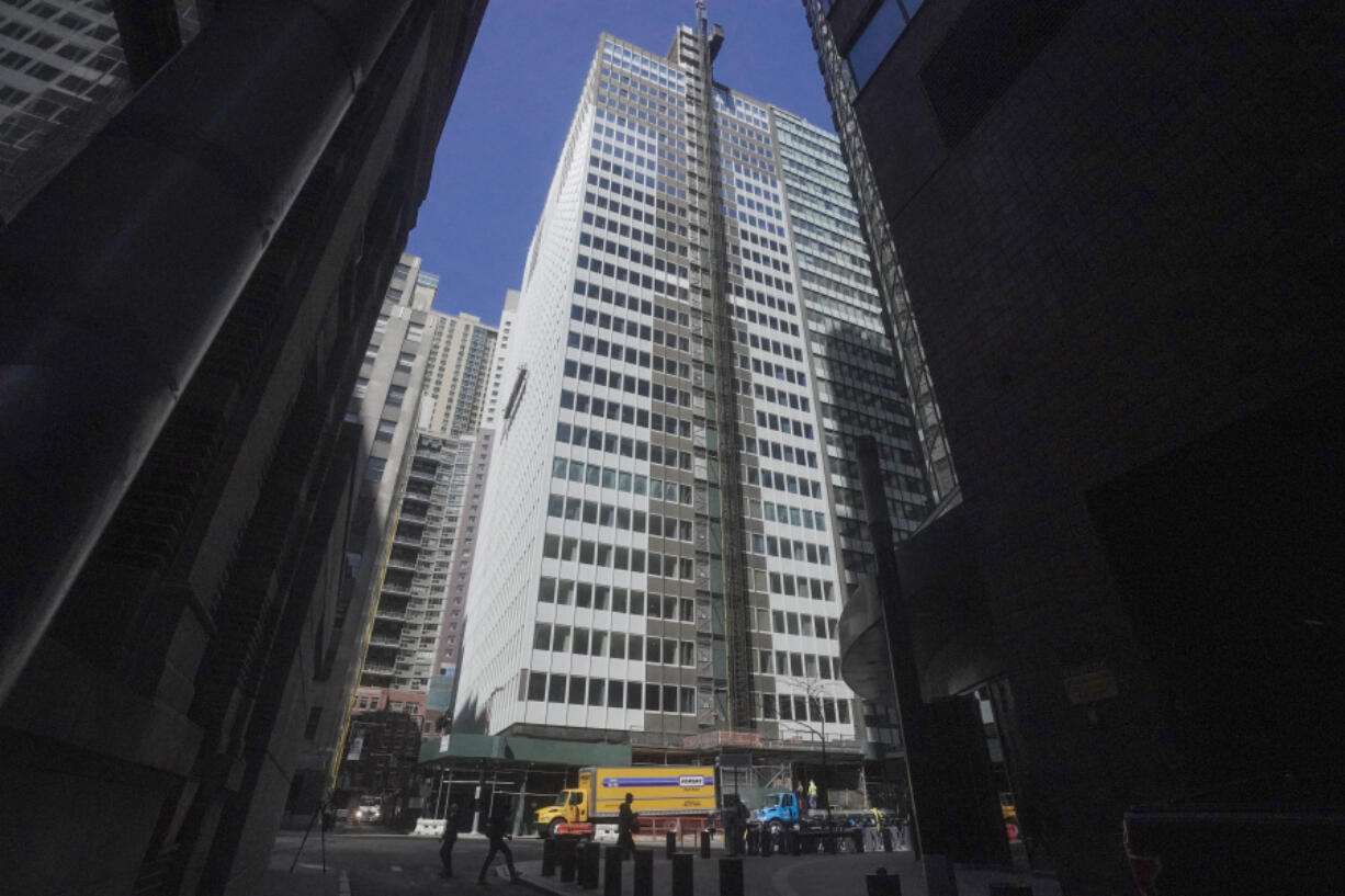 A high rise at 160 Water Street in Manhattan's financial district undergoing a conversion to residential apartments, is shown between the shadows of towering skyscrapers, Tuesday, April 11, 2023, in New York.