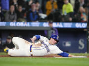 Seattle Mariners' Ty France slides to score on a single by Jarred Kelenic against the Colorado Rockies during the sixth inning of a baseball game Sunday, April 16, 2023, in Seattle.