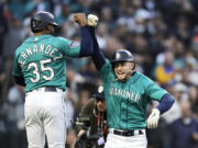 Seattle Mariners left fielder Jarred Kelenic, right, celebrates after his home run with Teoscar Hernandez after they scored off a throw by Colorado Rockies starting pitcher Austin Gomber during a baseball game, Friday, April 14, 2023, in Seattle.