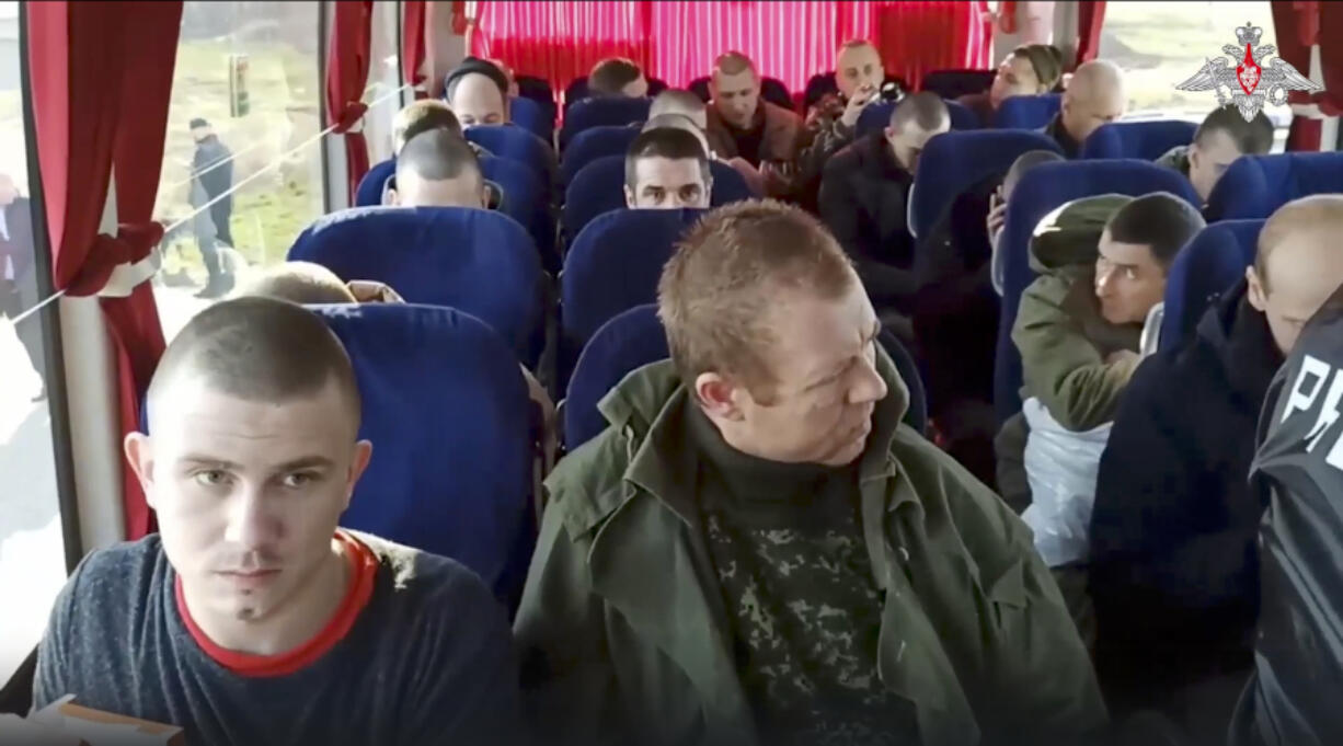 Russian soldiers sit inside a bus Monday after being released in a prisoner swap between Russia and Ukraine, at an unspecified location in Russia.