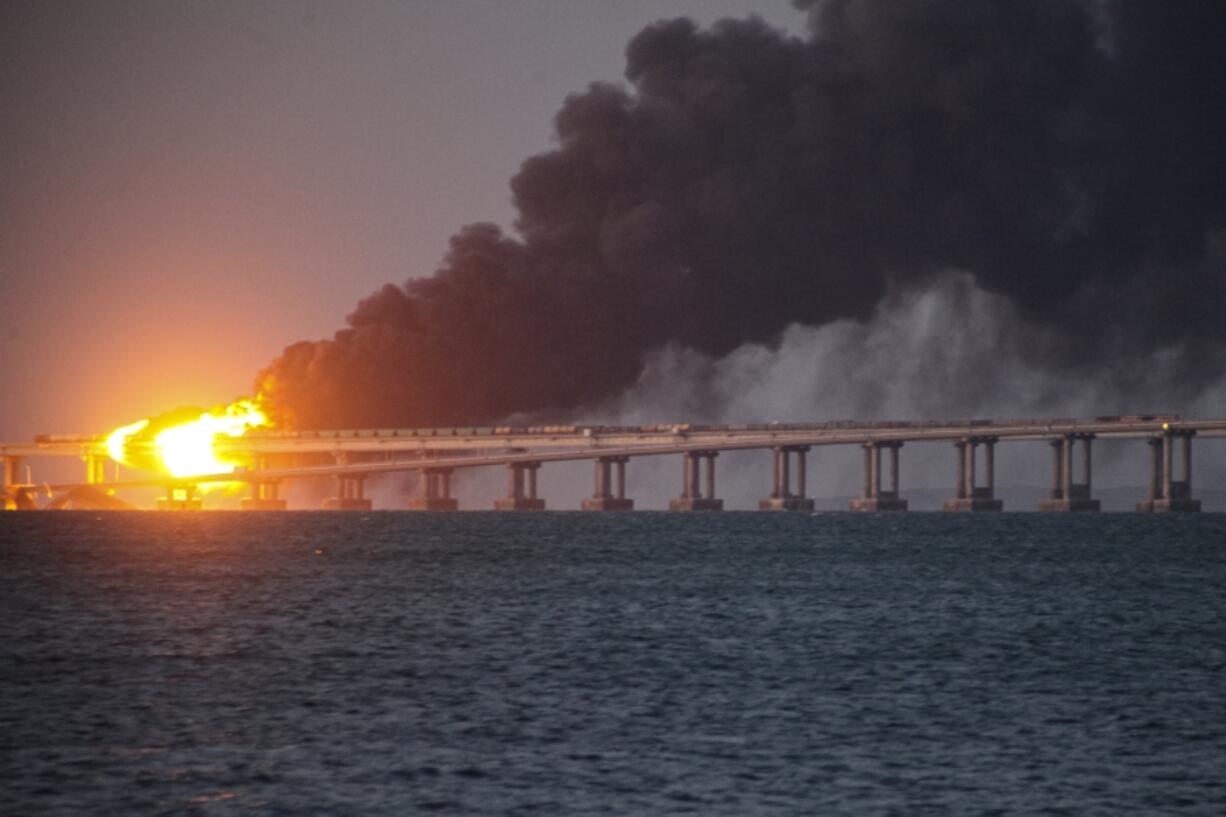 FILE - Flame and smoke rise from Crimean Bridge connecting Russian mainland and Crimean peninsula over the Kerch Strait, after what Russian authorities said was a bomb caused fire and partial collapse of the bridge, in Kerch, Crimea, Saturday, Oct. 8, 2022. A top Ukrainian official on Sunday, April 2, 2023, outlined a series of steps the government in Kyiv would take after the country reclaims control of Crimea, including dismantling the strategic bridge that links the seized Black Sea peninsula to Russia.