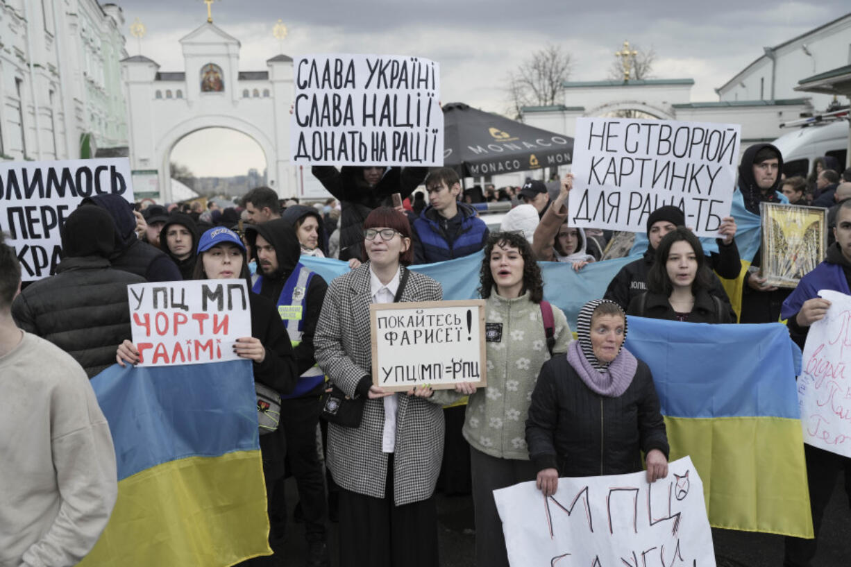 People protest outside the Kyiv Pechersk Lavra monastery complex by Ukrainian Orthodox Church in Kyiv, Ukraine, Saturday, April 1, 2023. In a bitter dispute over a famed Orthodox monastery, Ukraine's top security agency notified a leading priest on Saturday that he was suspected of justifying Russia's aggression, a criminal offense, Metropolitan Pavel, the abbot of the Kyiv-Pechersk Lavra monastery, Ukraine's most revered Orthodox site, has resisted the authorities' order to vacate the complex. Earlier in the week, he cursed Ukrainian President Volodymyr Zelenskyy, threatening him with damnation.