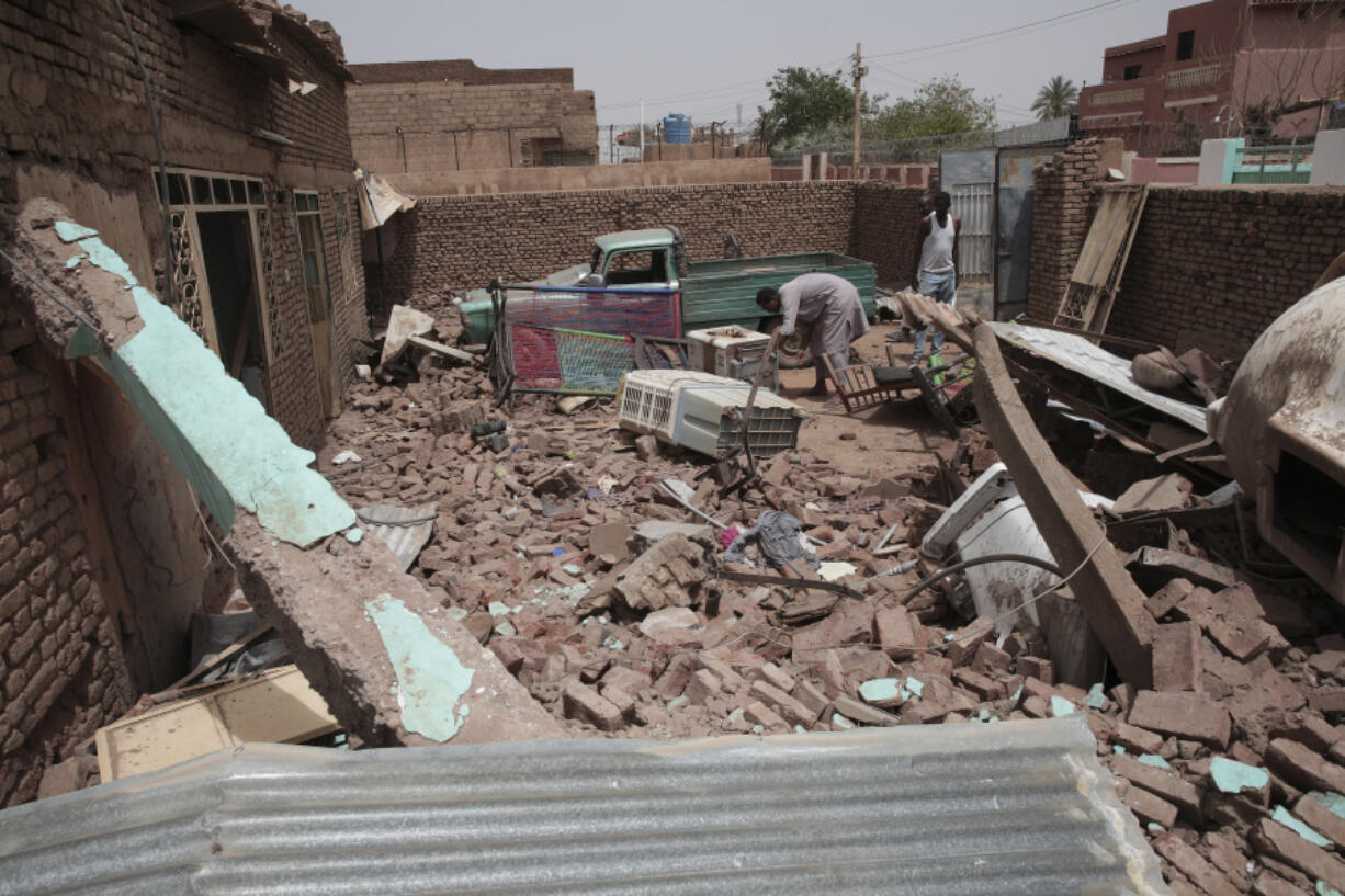 A man cleans debris of a house hit in recent fighting in Khartoum, Sudan, Tuesday, April 25, 2023. Sudan's warring generals have pledged to observe a new three-day truce that was brokered by the United States and Saudi Arabia to try to pull Africa's third-largest nation from the abyss.