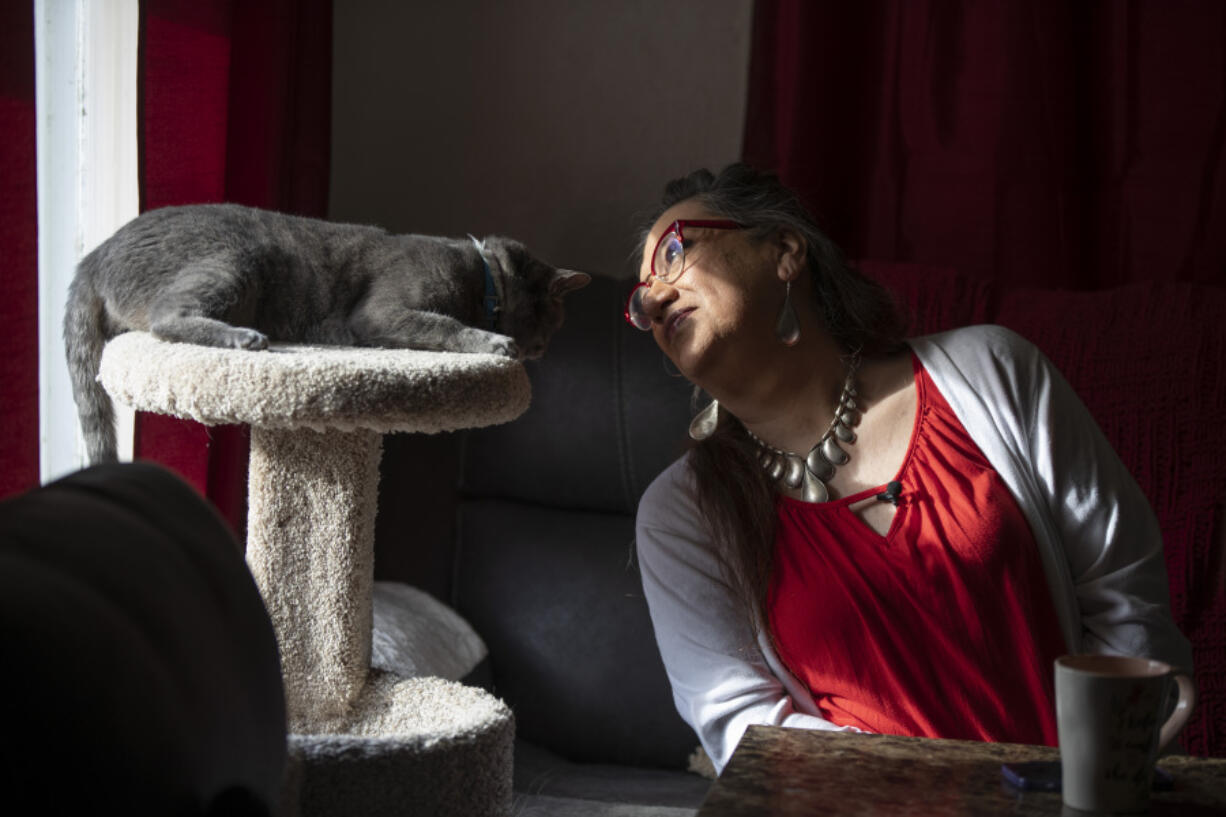 Christina Wood sits beside her cat, Miss Kitty, in her home in Salem, Ore., Friday, April 21, 2023. For most of her life in New Mexico, Wood felt like she had to hide her identity as a transgender woman. So six years ago she moved to Oregon, where she could access the gender-affirming health care she needed to live as her authentic self.