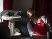 Christina Wood sits beside her cat, Miss Kitty, in her home in Salem, Ore., Friday, April 21, 2023. For most of her life in New Mexico, Wood felt like she had to hide her identity as a transgender woman. So six years ago she moved to Oregon, where she could access the gender-affirming health care she needed to live as her authentic self.