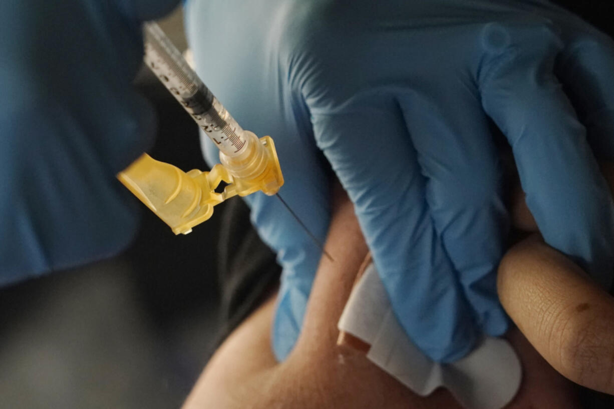 A nurse administers a Moderna COVID-19 booster vaccine at an inoculation station next to Jackson State University in Jackson, Miss., Friday, Nov. 18, 2022.  U.S. regulators on Tuesday, April 18, 2023,  cleared another COVID-19 booster dose for older adults and people with weak immune systems so they can shore up protection this spring -- while taking steps to make coronavirus vaccinations simpler for everyone else.(AP Photo/Rogelio V.