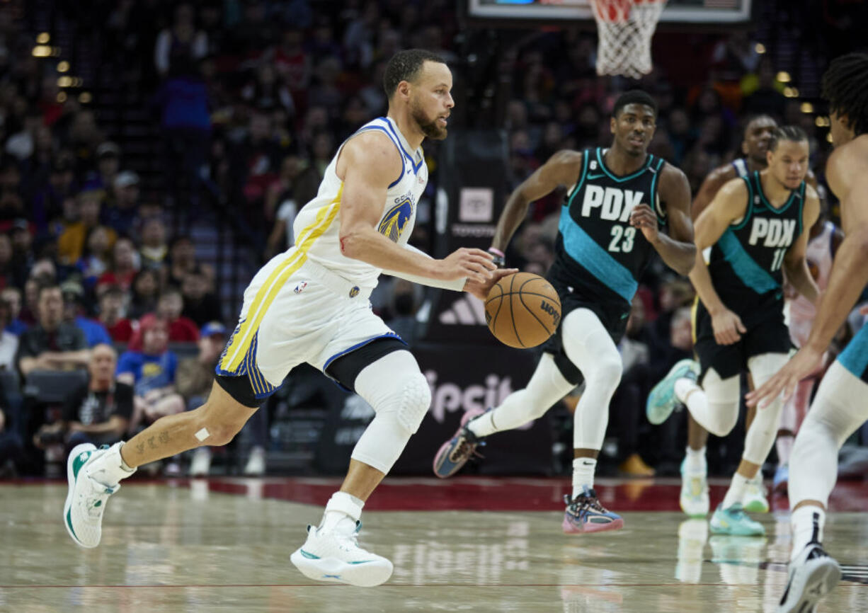 Golden State Warriors guard Stephen Curry drives to the basket against the Portland Trail Blazers during the second half of an NBA basketball game in Portland, Ore., Sunday, April 9, 2023.