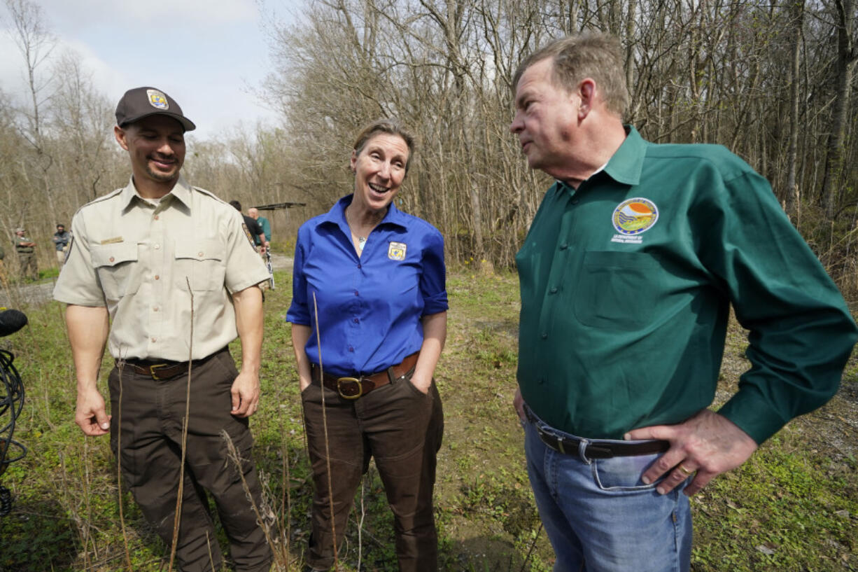 FILE - Martha Williams Director of the U.S. Fish and Wildlife Service, center, talks with Jimmy Laurent, regional energy coordinator for U.S. Fish and Wildlife, left, and Thomas Harris, Secretary for the Louisiana Department of Natural Resources, as they visit the B-5 orphan well site in the Atchafalaya National Wildlife Refuge in Lottie, La., Thursday, Feb. 16, 2023. Dozens of scientists from universities across the nation are challenging whether Williams has the education needed to run an agency in charge of managing endangered species.