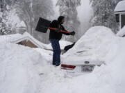 FILE - Kenny Rybak shovels snow around his car in Running Springs, Calif., Tuesday, Feb. 28, 2023. Since December, 2022, a parade of a dozen atmospheric storms have dumped so much snow up and down the Sierra that several ski resorts around Lake Tahoe have had to shut down multiple times. The National Weather Service in Reno recently called it the "winter that just doesn't want to end." (AP Photo/Jae C.