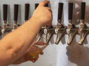 A bartender pours a taster of a beer at Vice Beer in east Vancouver. Vice plans to open a taproom in downtown Vancouver, as well. Top: Beers sit on the bar at Vice Beer in east Vancouver.