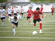 Camas freshman Luke Manandic, right, and Bellarmine Prep’s Jack Merriam scramble for a loose ball during a Class 4A bi-district boys soccer game on Saturday, May 6, 2023, at Doc Harris Stadium.