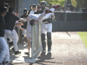 Camas first baseman Boston Jensen falls over the railing of the Camas dugout while chasing a foul ball during a bi-district first-round game against Sumner on May 9, 2023 at Camas High School.