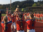 Ridgefield softball players hoist the 2A district trophy after beating Centralia 5-2 in the championship game on Friday, May 19, 2023, at Recreation Park in Chehalis.