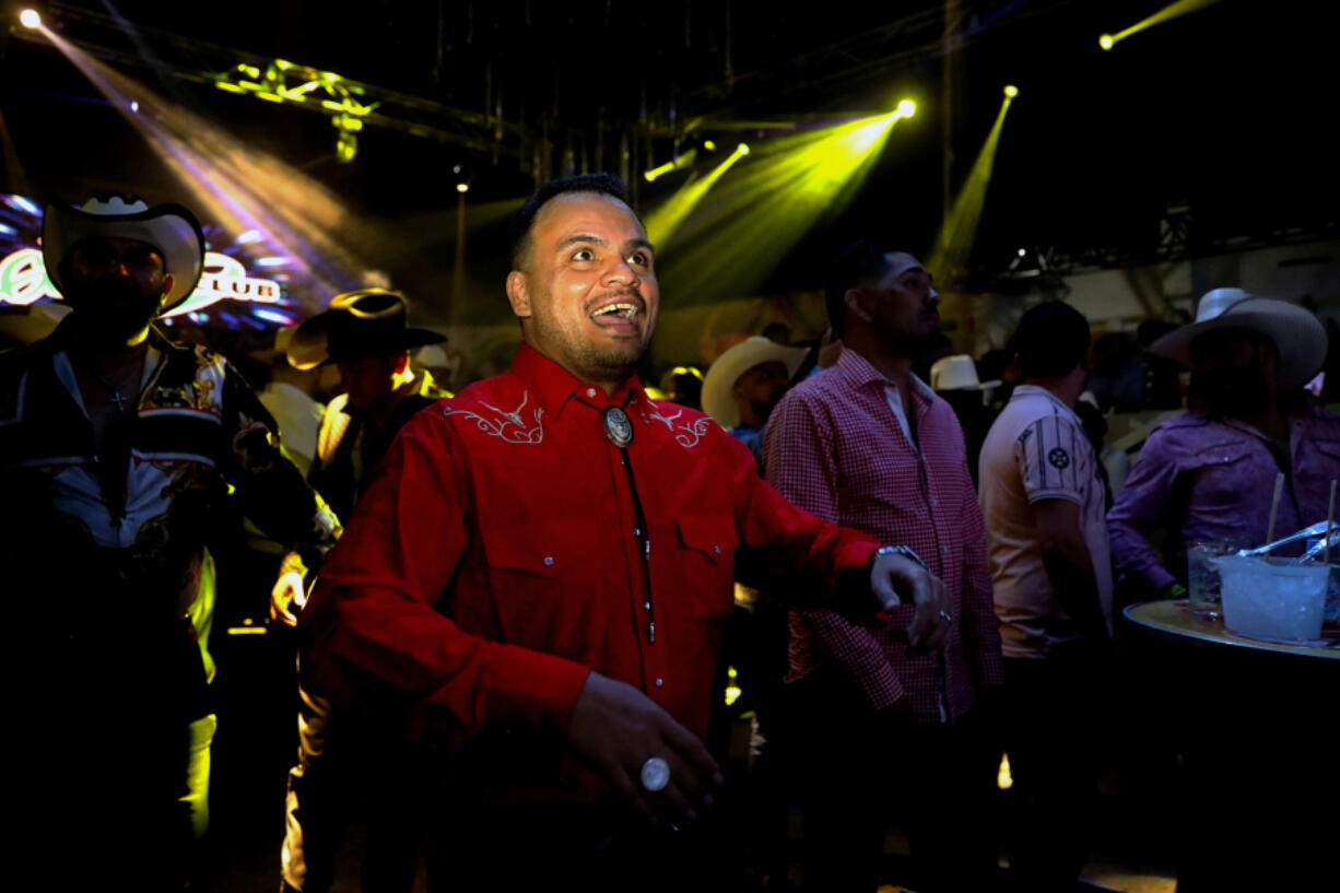 Enrique Palacio, 34, of Zacatecas copies the dance moves of the musical group La Sonora Dinamita as it performs at the convention.