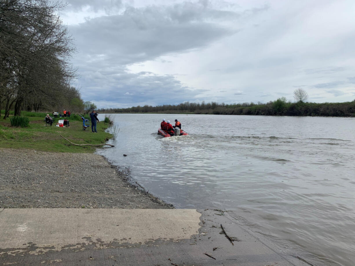 Fire crews rescue a father and two teenage boys Sunday after their rowboat sank in Vancouver Lake.