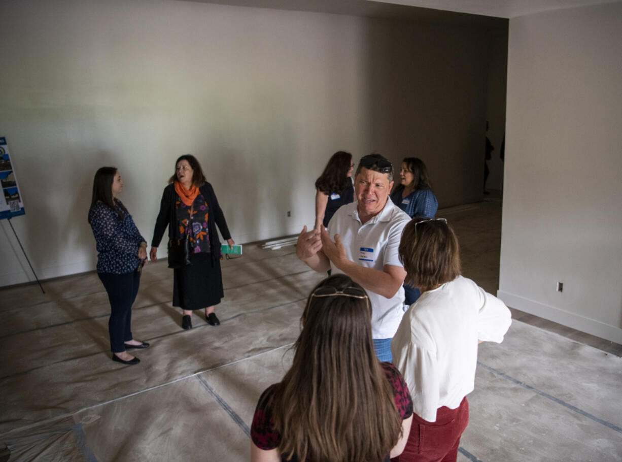 Clark County Building Industry Association Treasurer and developer of the project, Dave Campos, third from right, gives a tour of a renovated building Wednesday during a groundbreaking for Community Roots Collaborative's new O-Street project. The project includes renovating a former Sikh Community Church into 12 Oxford-style homes and adding eight tiny homes on the property.