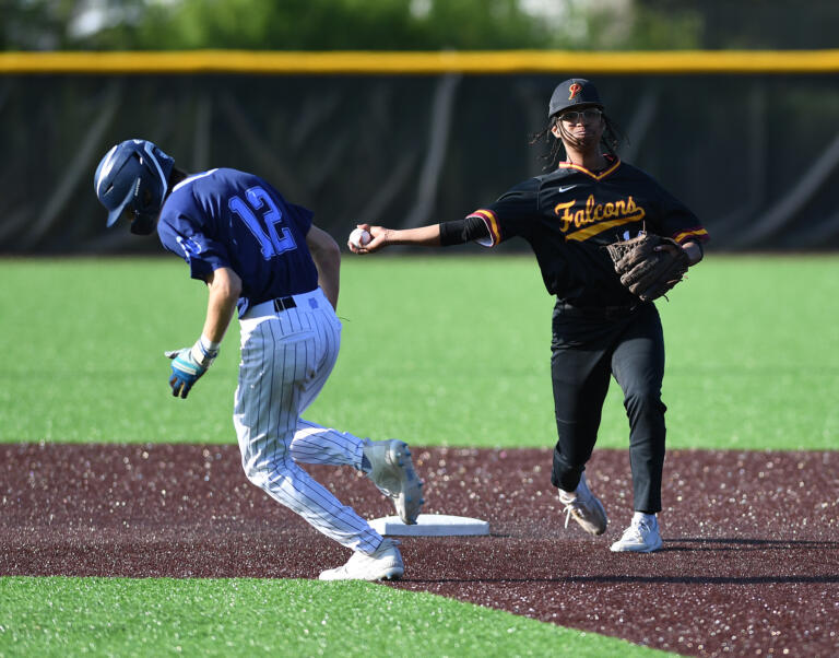 Prairie senior Dylan Gaylor, right, throws the ball to first baseTuesday, May 9, 2023, during the Falcons’ 12-4 loss to Gig Harbor in a 3A bi-district playoff game at the Evergreen Athletic Annex.