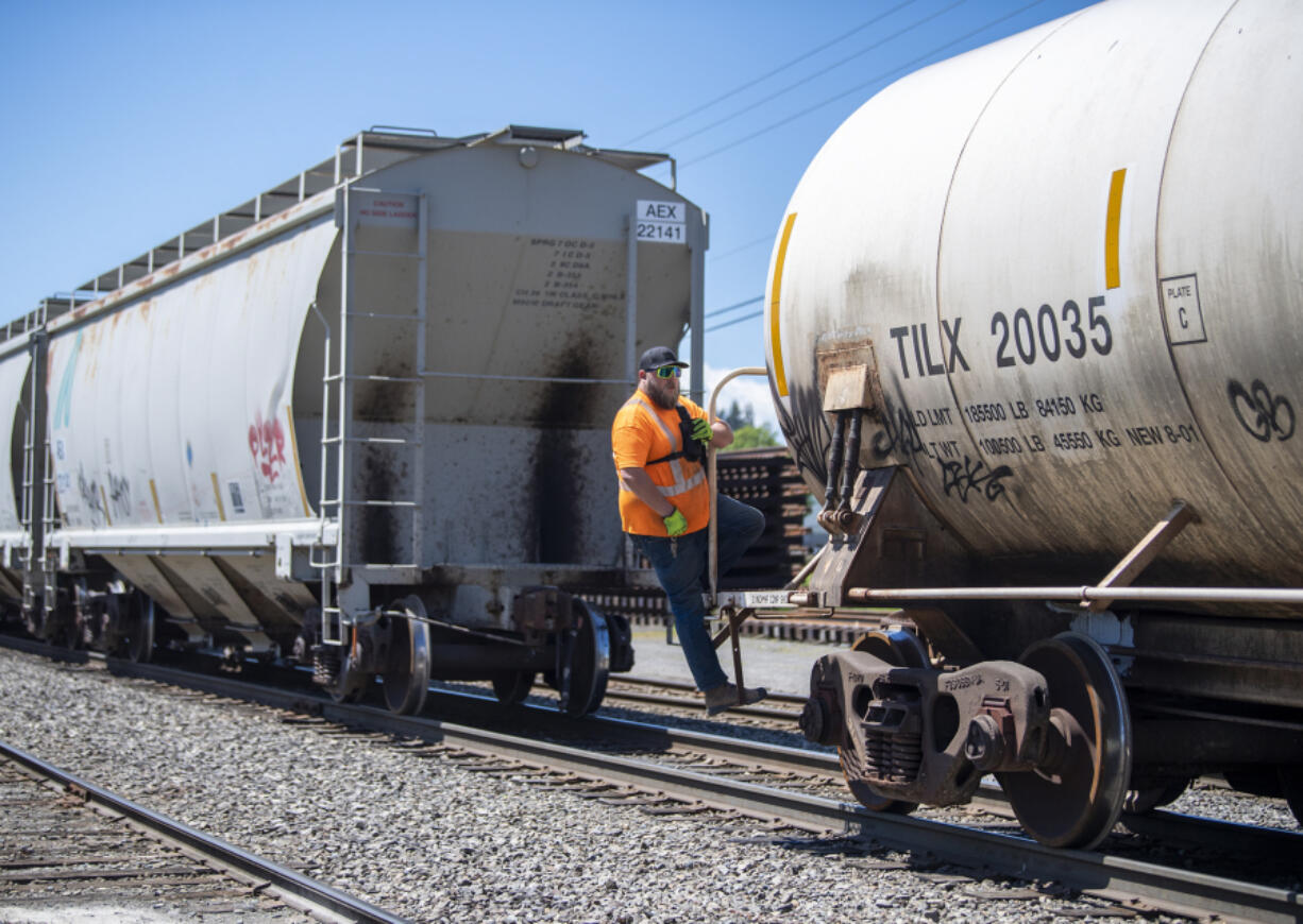 Portland Vancouver Junction Railroad conductor Brad Johnston rides along the Chelatchie Railroad line while working near St. Johns Road. On Wednesday, the Clark County Council continued its debate on whether to allow heavy industrial development along the line.