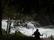 A hiker takes in a scenic view as springtime sunshine illuminates rushing water while it pours over the rocky cliffs of Lucia Falls. Forecasters predict the sunshine will stay around for the rest of the week with summerlike temperatures over the weekend.