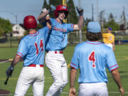 Mark Morris senior Langston Bartell, center, celebrates with teammates after hitting a home run Friday, May 12, 2023, during the Monarchs’ 8-4 win against Columbia River in a 2A district baseball playoff game at the Ridgefield Outdoor Recreation Complex.