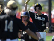 Hudson's Bay senior Sabastian Laddusaw (12) celebrates after scoring a run Friday during the Eagles' 10-4 win against Ridgefield in a 2A district baseball winner-to-state game at the Ridgefield Outdoor Recreation Complex.