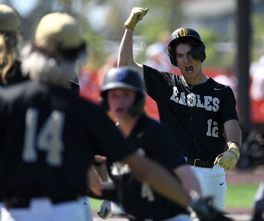 Hudson's Bay senior Sabastian Laddusaw (12) celebrates after scoring a run Friday during the Eagles' 10-4 win against Ridgefield in a 2A district baseball winner-to-state game at the Ridgefield Outdoor Recreation Complex.