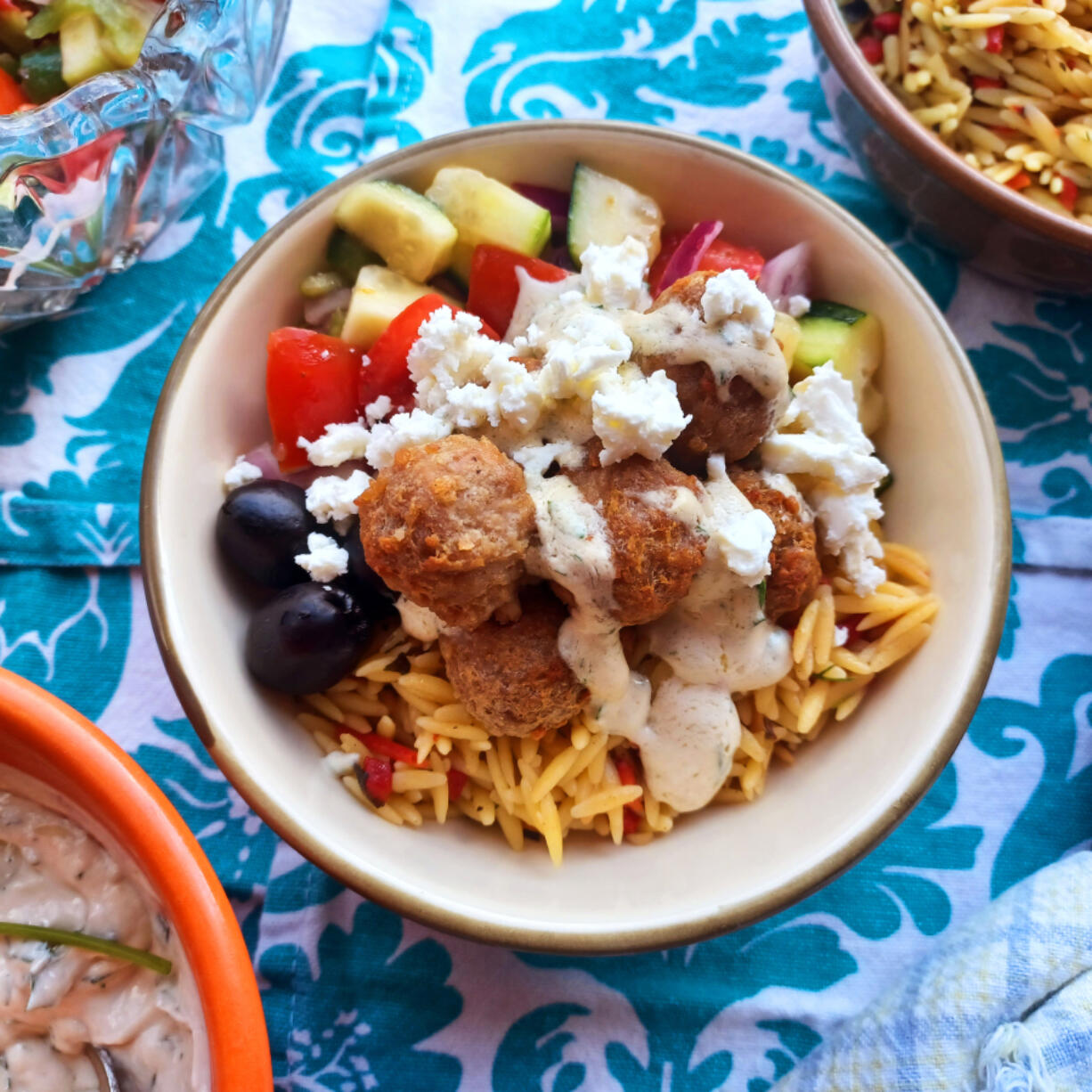 With a garlicky lemon orzo, crunchy Greek salad and addictive lemon tahini sauce, your meatballs will never be the same.