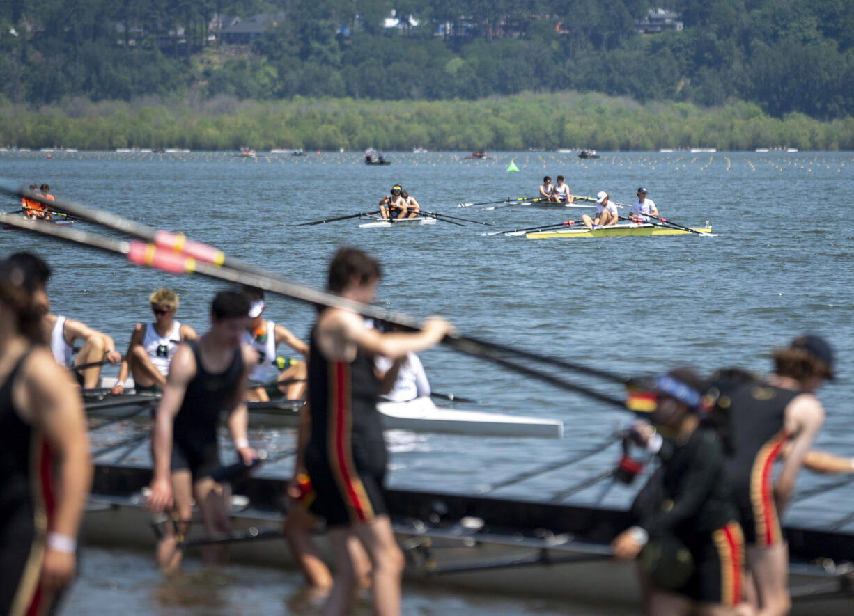 Rowers in the foreground exit Vancouver Lake after their races while others paddle out to the starting line Friday, May 19, 2023, during the U.S. Rowing Northwest Youth Championship Regatta at Vancouver Lake Park. The three-day event is expected to draw between 1,500 and 3,000 rowers over the course of the competition.